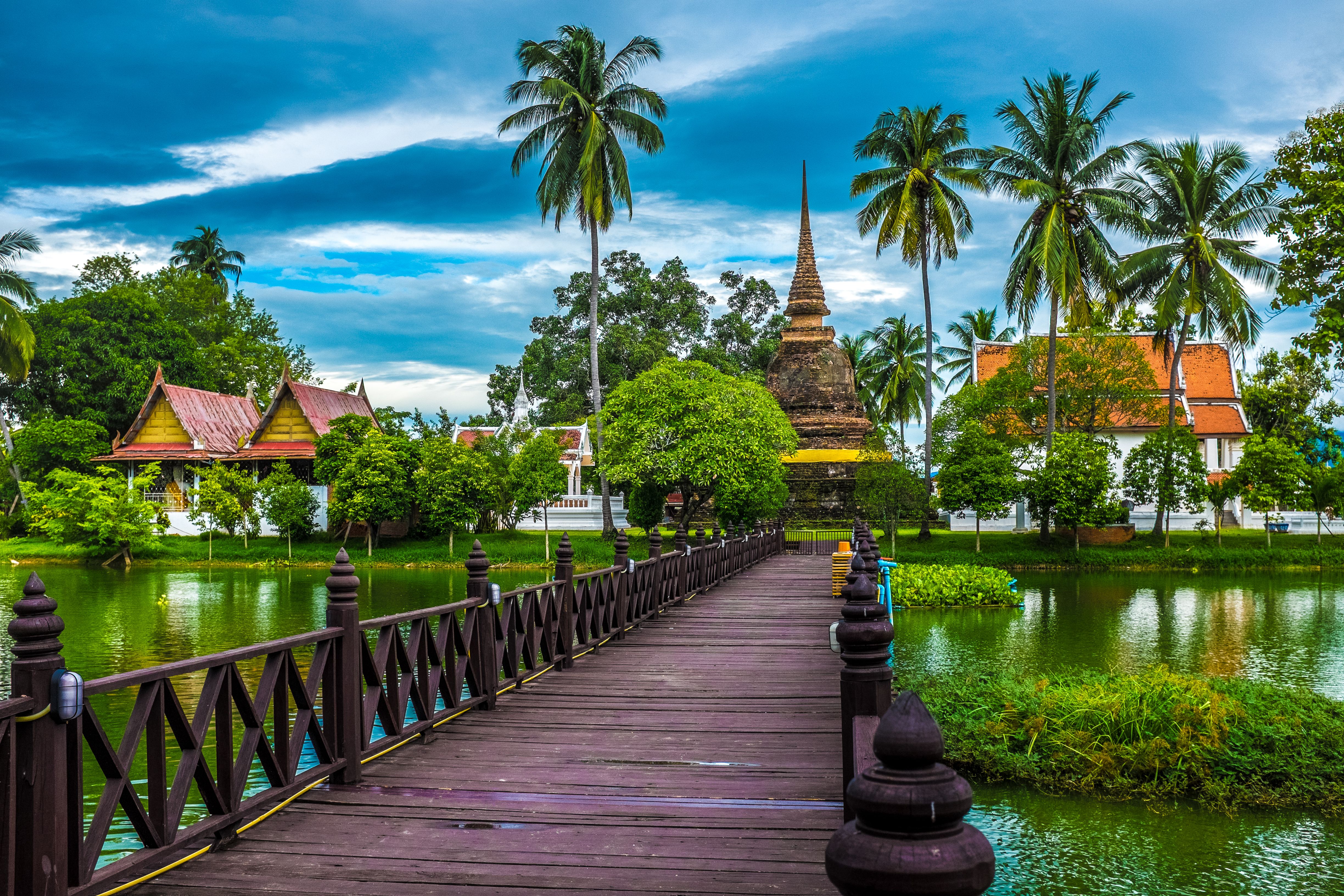 Thailand temple with palm trees and reflection bridge