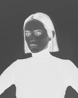 Woman in black turtleneck on white background in inverted grayscale