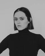 Woman in black turtleneck on white background in grayscale