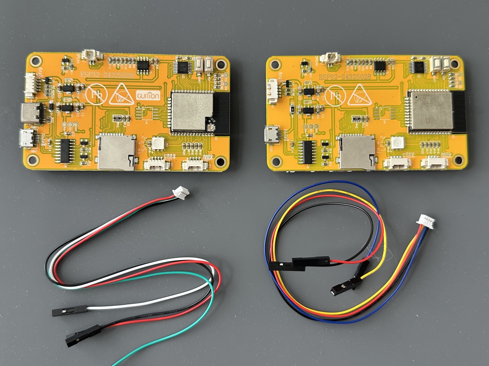 Two ESP32-2432S028 boards and two included cable harness examples
