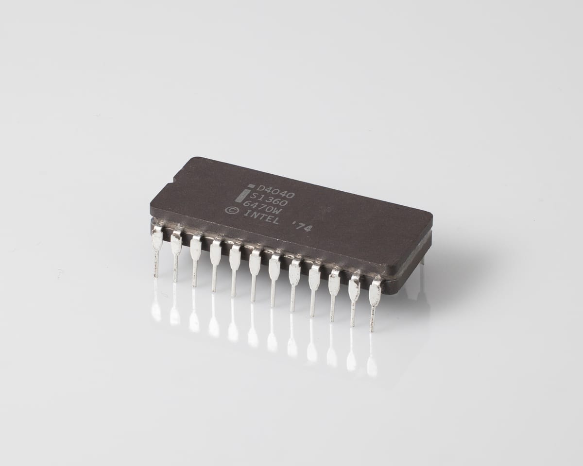 Intel D4040 processor, three-quarter view: grey ceramic 24-pin DIP marked 'i D4040 S1360 6470W ©INTEL '74', silver pins