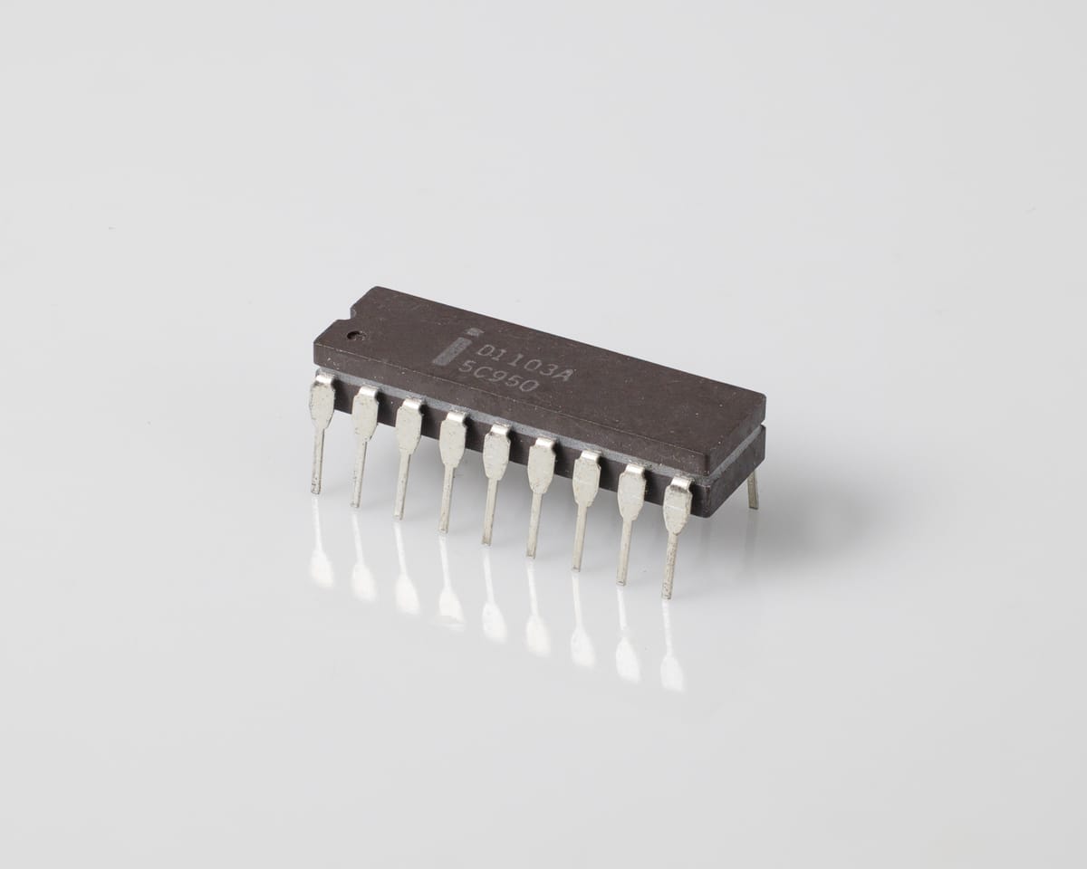 Intel D1103A chip, three-quarter view: grey ceramic 18-pin DIP marked 'i D1103A 5C950', silver pins