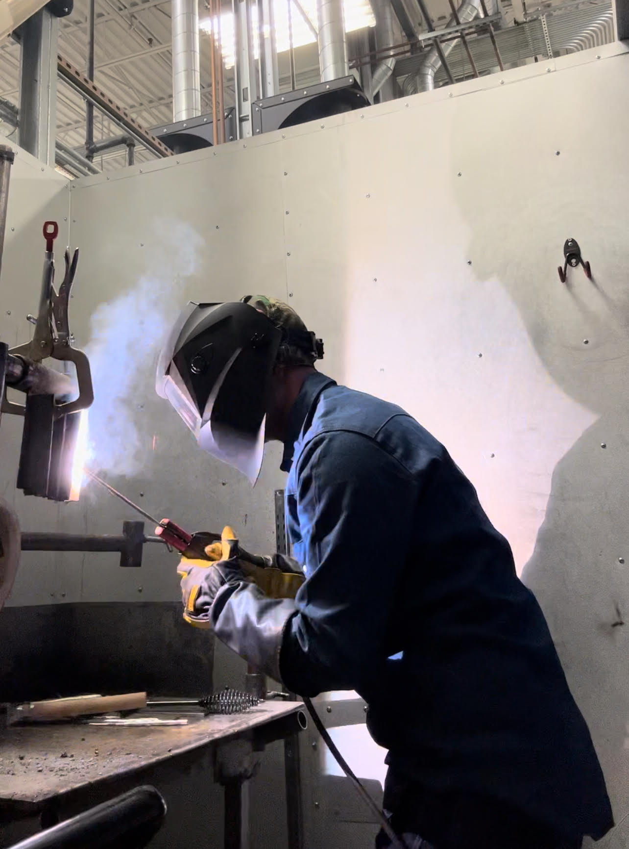 Zach welding in an industrial shop