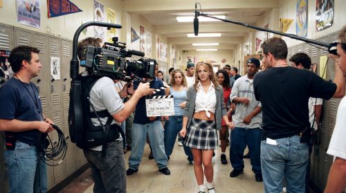 A live television camera operator on the set of Britney Spears' "...Baby One More Time" music video, capturing the ic…