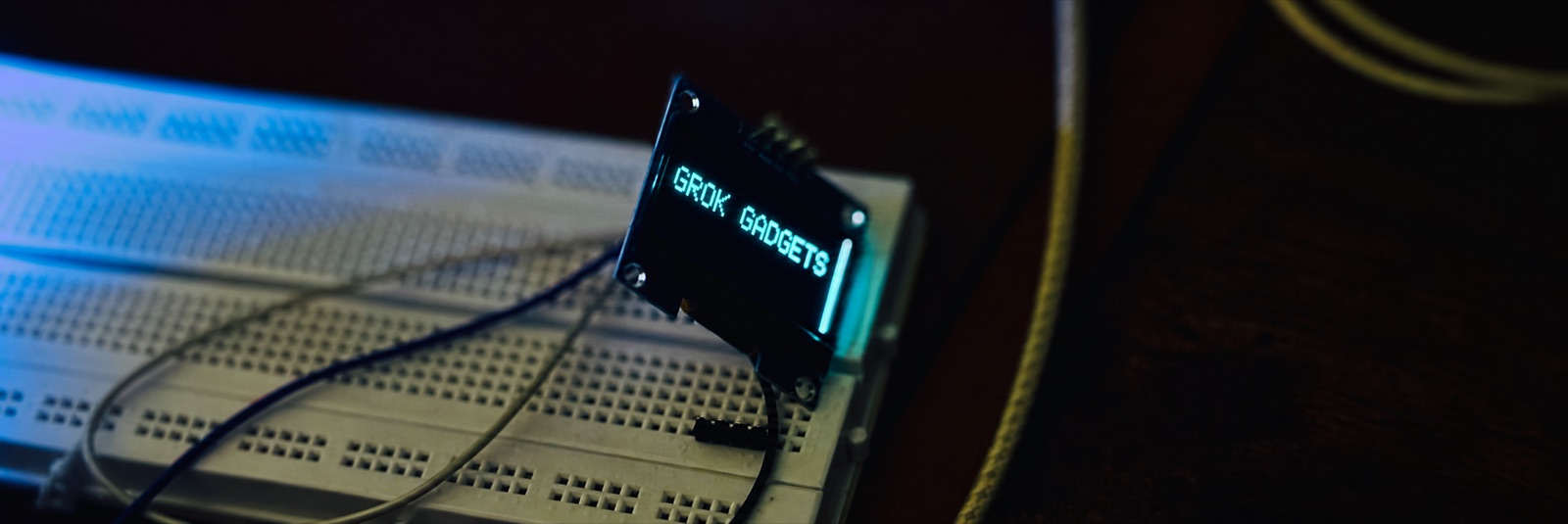 Grok Gadgets shown on a small OLED display mounted on a breadboard.