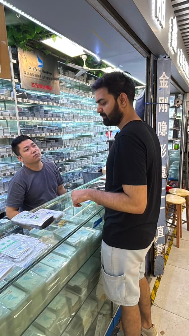 Shaikh China Sourcing representative speaking with a supplier in a Chinese wholesale market