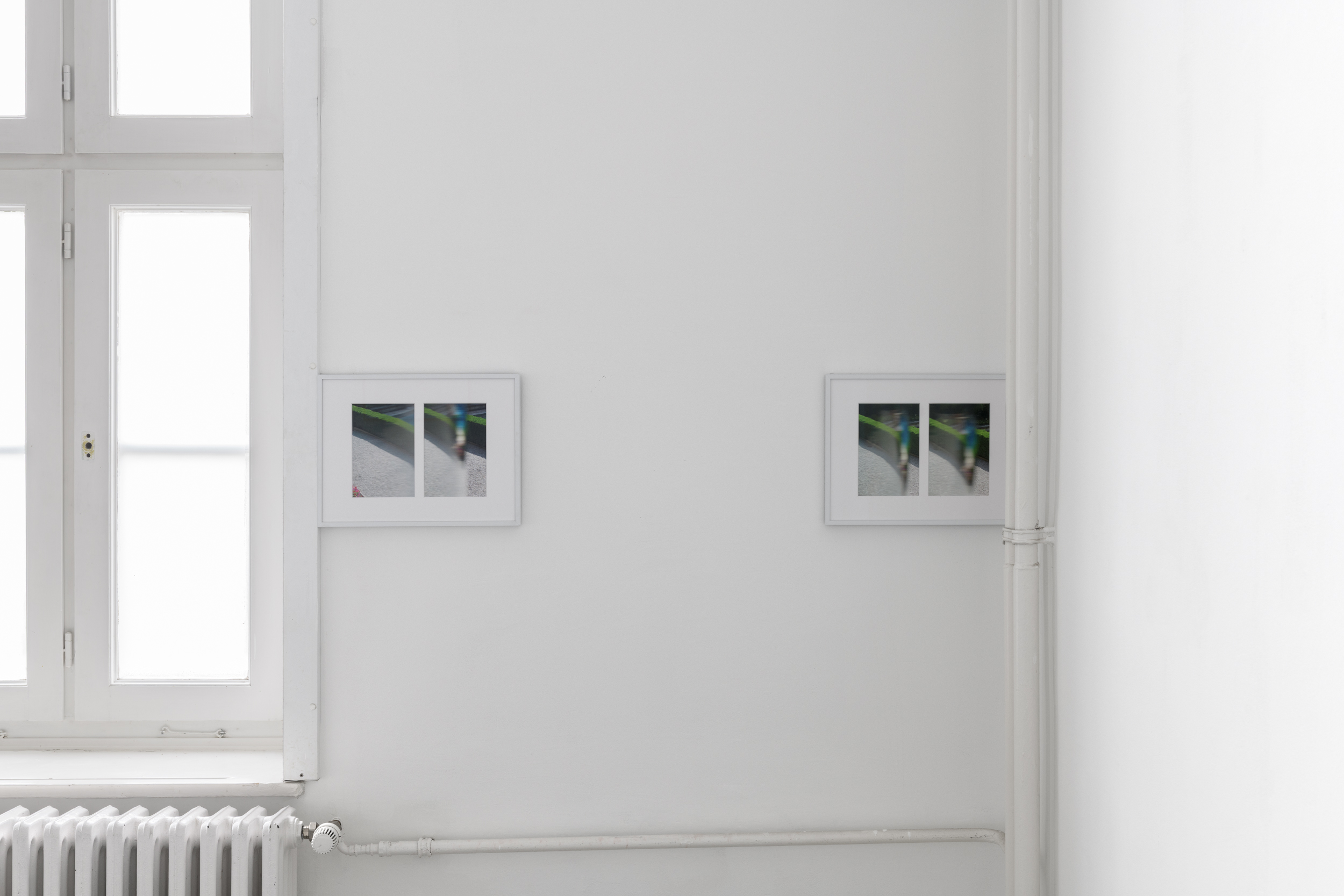 Aisha Altenhofen, The Carrier at UdK Berlin: Detailed view of two photographs; one is mounted flush against the window frame, the other sits adjacent on the primary wall.