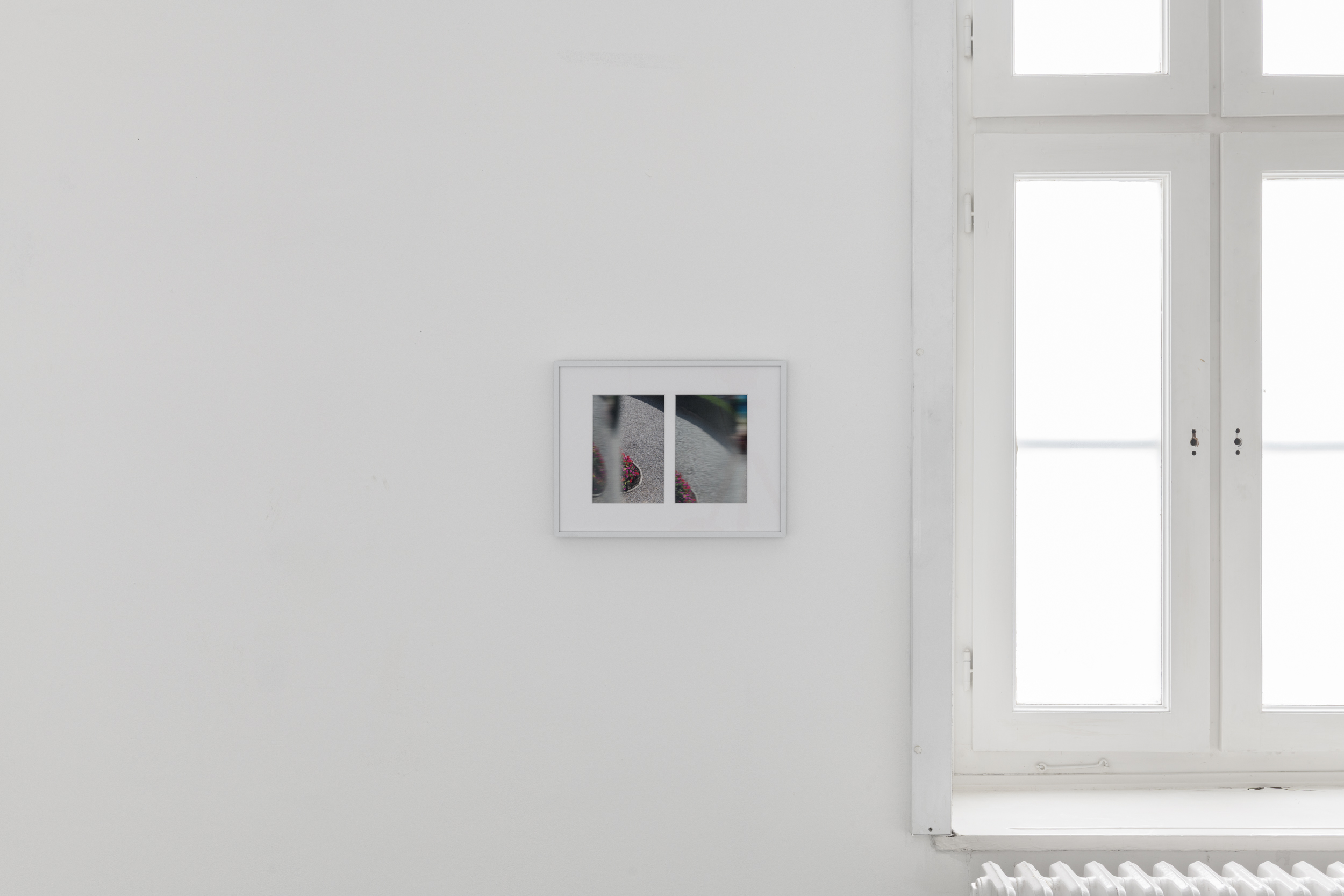 Aisha Altenhofen, The Carrier at UdK Berlin: Close-up of a photographic work installed to the left of the window, positioned with a deliberate gap between the frame and the image.