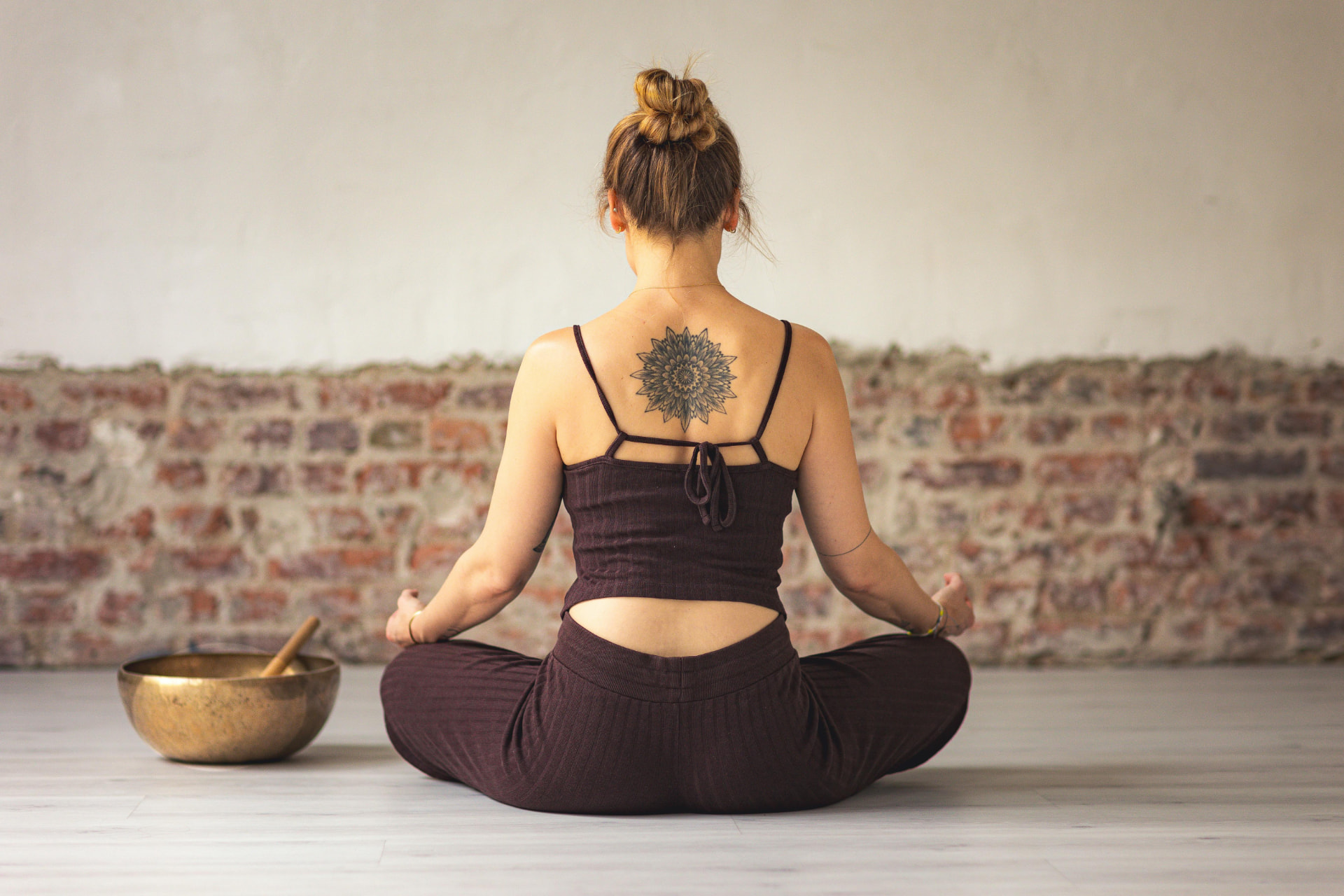 Woman sitting with mandala tattoo on back