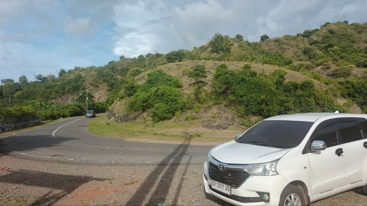 Toyota Avanza putih FF Taxi Sumbawa di jalur wisata Sumbawa