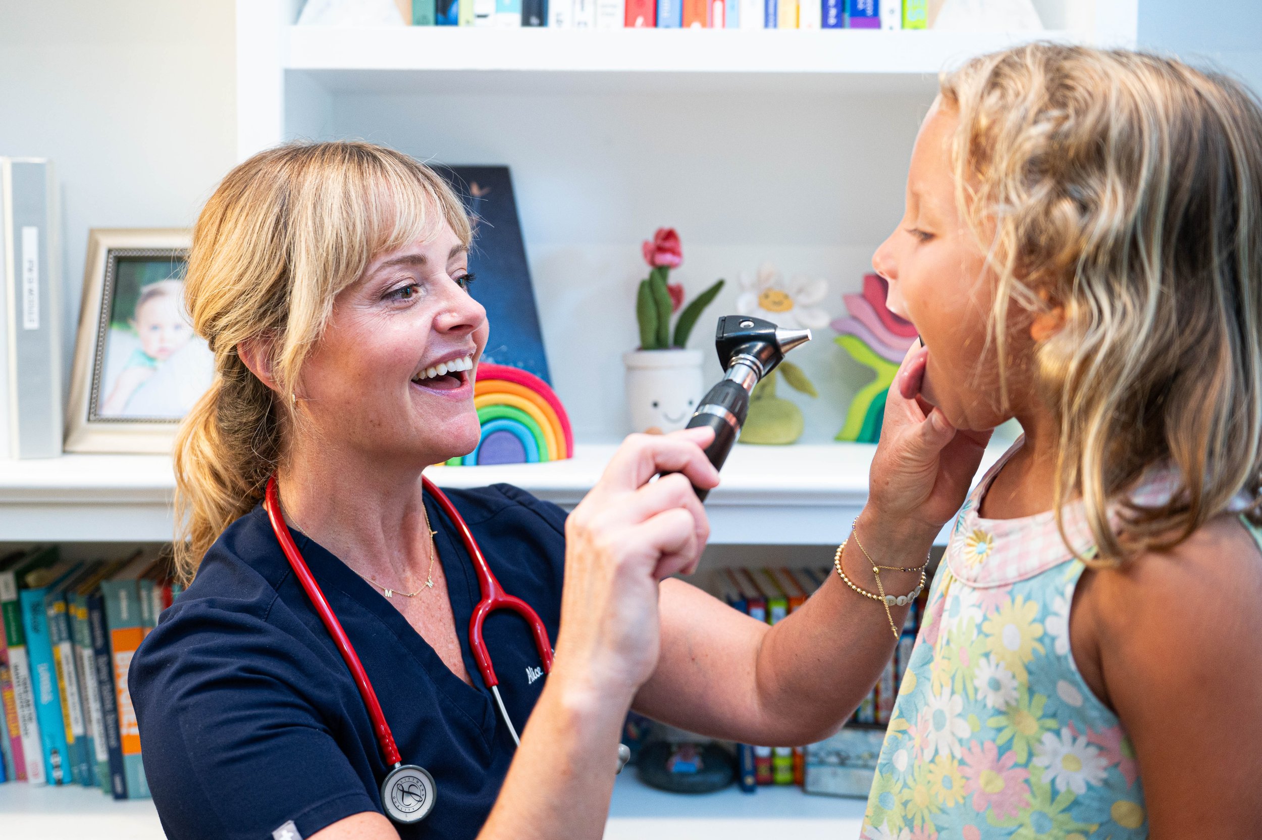 Alice examining a girl with an otoscope