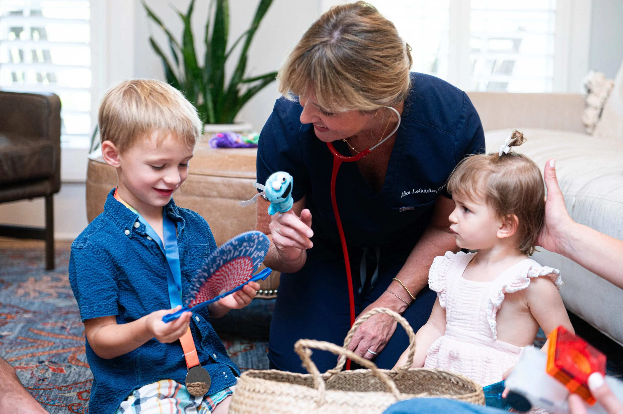 Alice on the floor playing with two kids