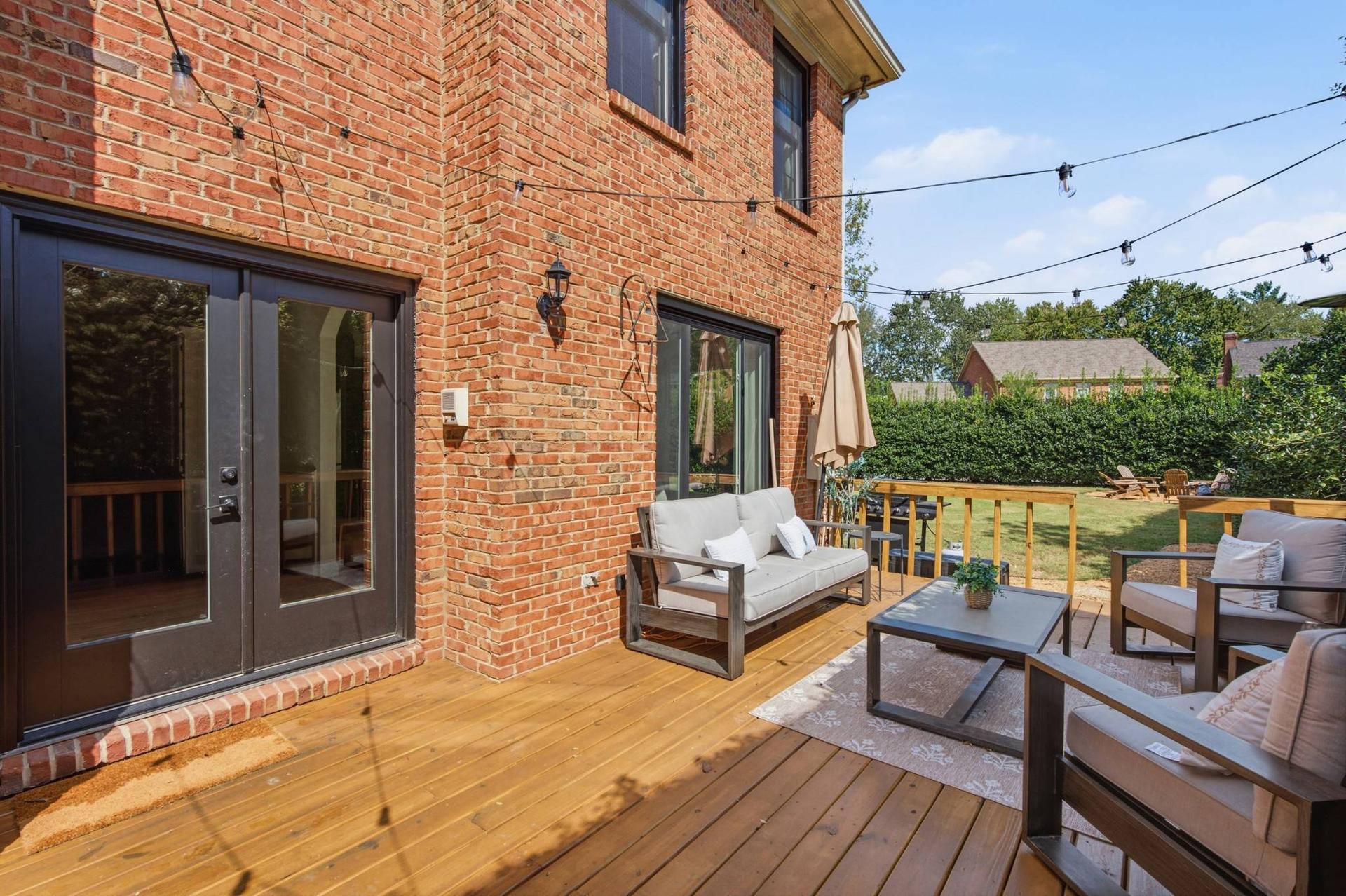 The open-air rear deck at 108 Sturbridge Drive, with outdoor seating against the brick elevation