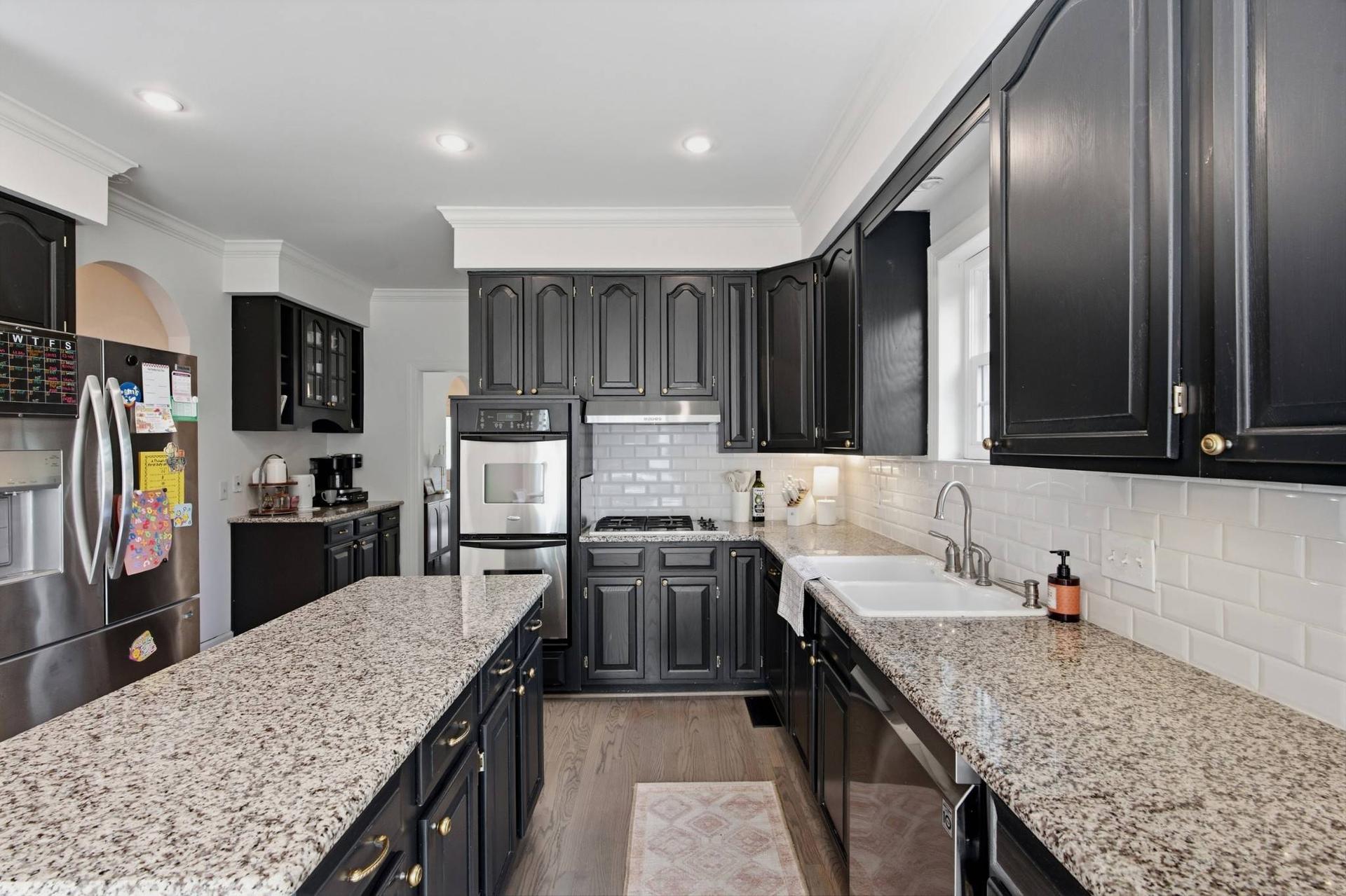 The kitchen at 108 Sturbridge Drive, with dark cabinetry, granite counters and a central island