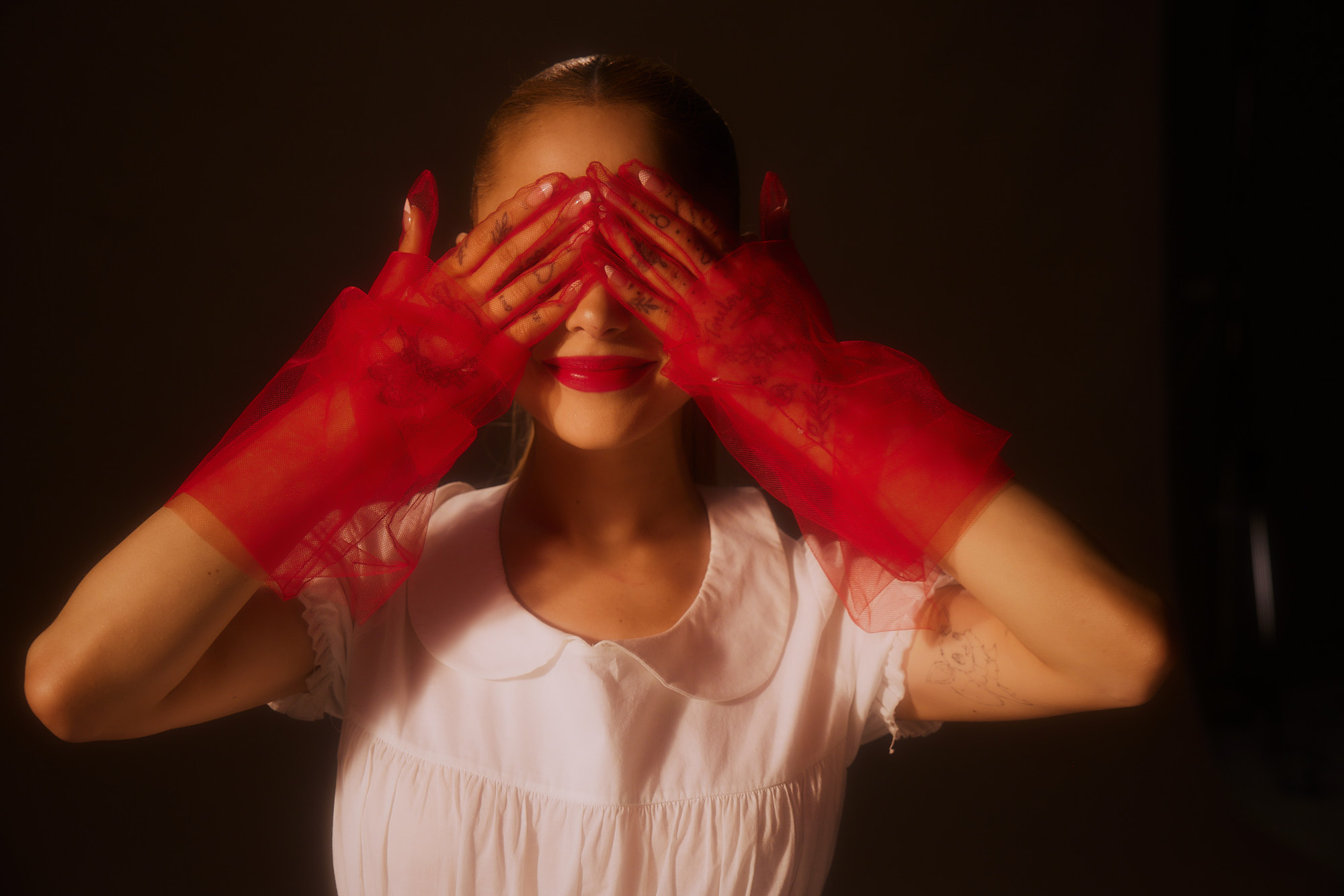 The obscured eyes suggest that true emotions or clarity are kept out of view.  It&rsquo;s like a mask of sorts, a poised facade maintained even as the eyes, the windows to the soul, are hidden.