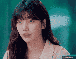 एक युवा महिला शांत वातावरण में विचारशीलता से देख रही है।