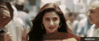 A woman walks confidently through a busy street, engaging with her surroundings.