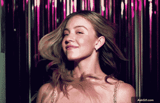 एक महिला मुस्कुराते हुए मजेदार तरीके से अपने बालों को झटकती है।