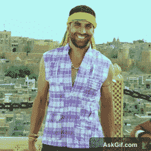 A man smiles confidently while wearing a colorful outfit.