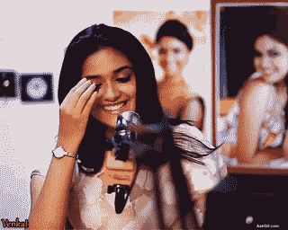 कीर्ति सुरेश साक्षात्कार के दौरान बालों को पीछे करते हुए मुस्कुरा रही हैं