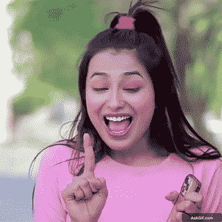 सुखमनी सदाना उत्साह से एक उंगली उठाते हुए मुस्कुरा रही हैं