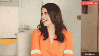 Radhika Madan Laughs Heartily While Sitting in a Bright Orange Outfit