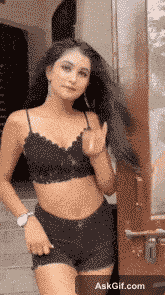 एक युवा महिला अपने घर के प्रवेश द्वार पर खेल-खेल में पोज़ देती है।