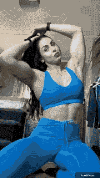Fitness enthusiast showcasing powerful arm workout in blue outfit.