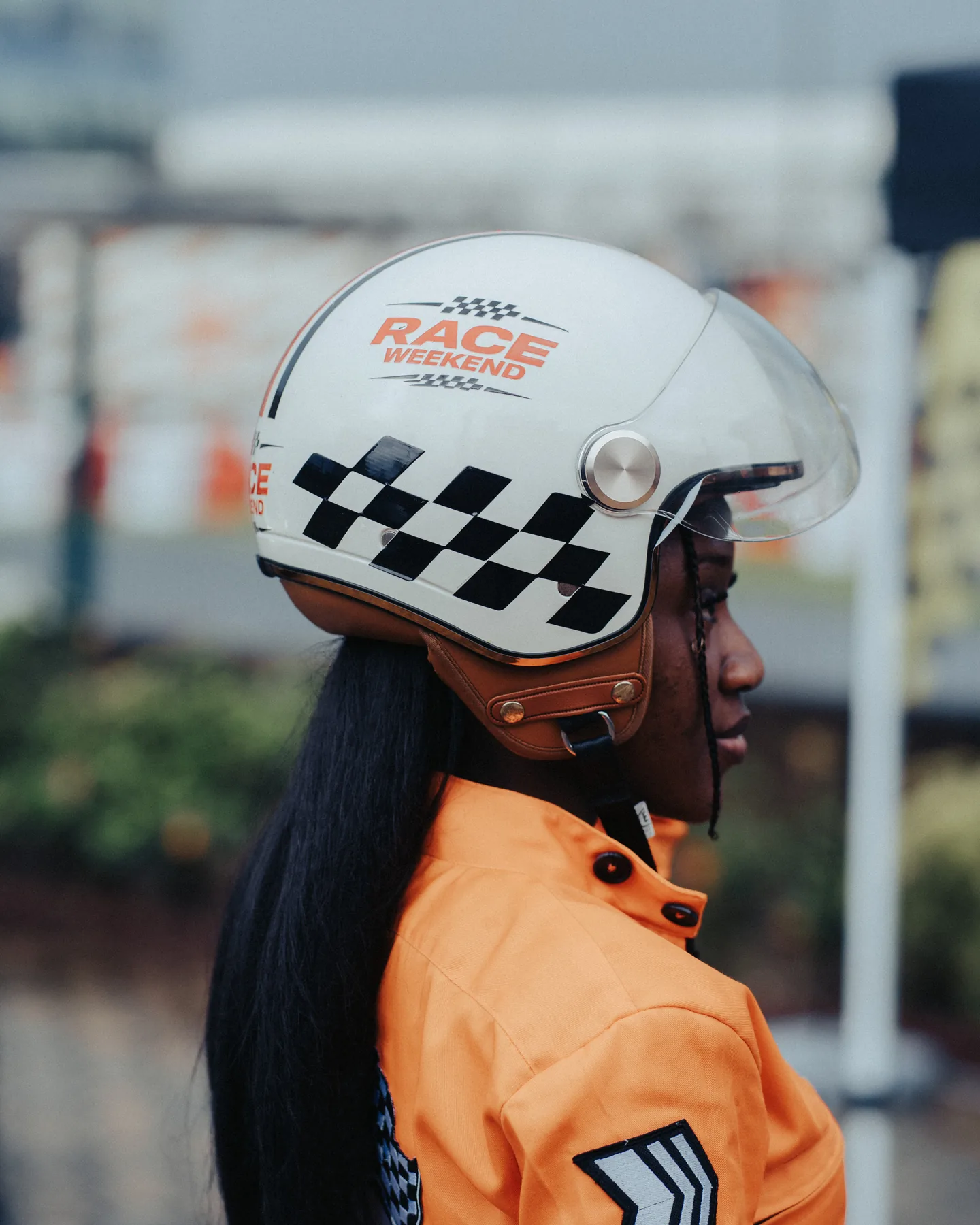Guest in racing overalls wearing a Race Weekend branded helmet
