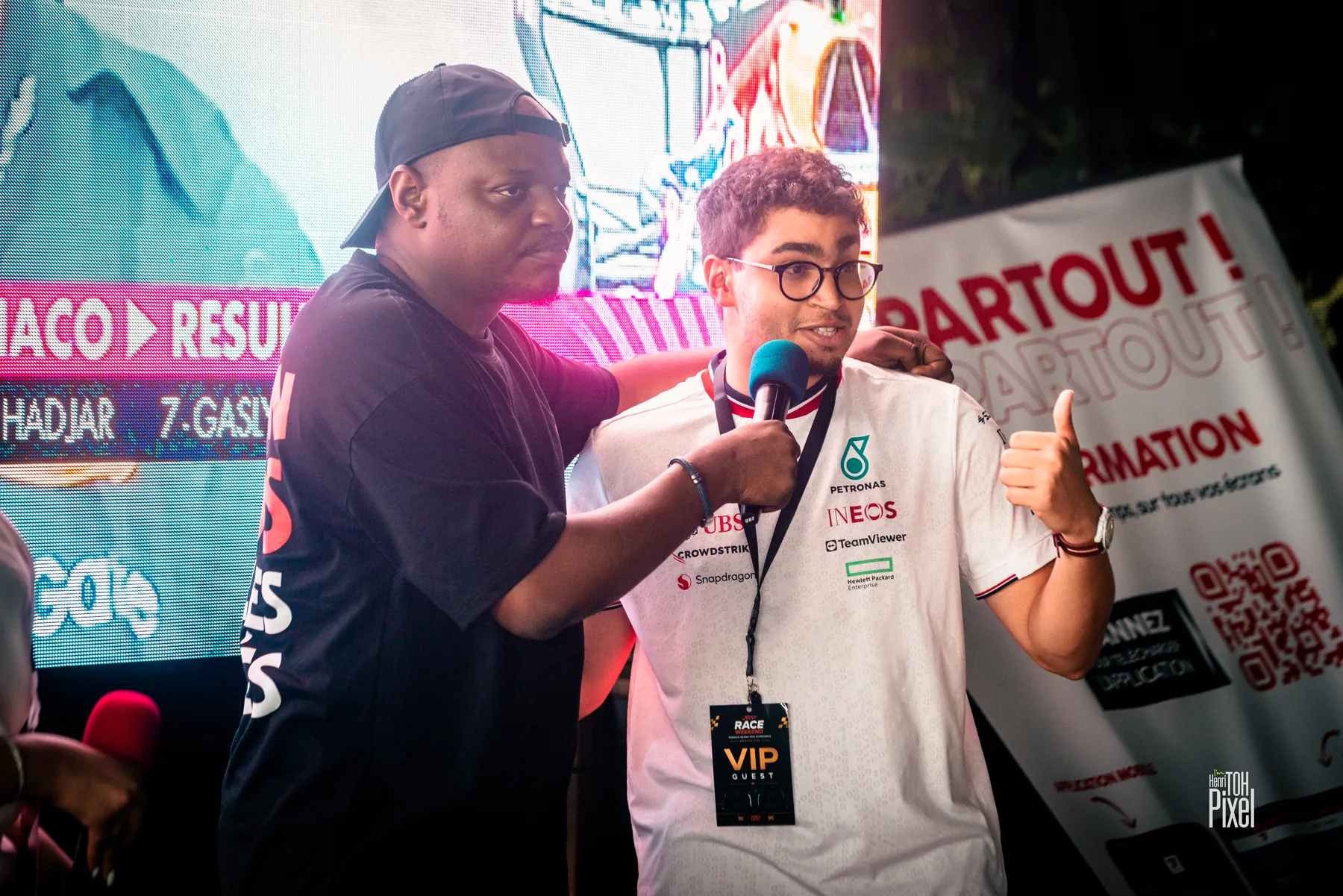 Host interviewing a guest in front of the Monaco Grand Prix results screen
