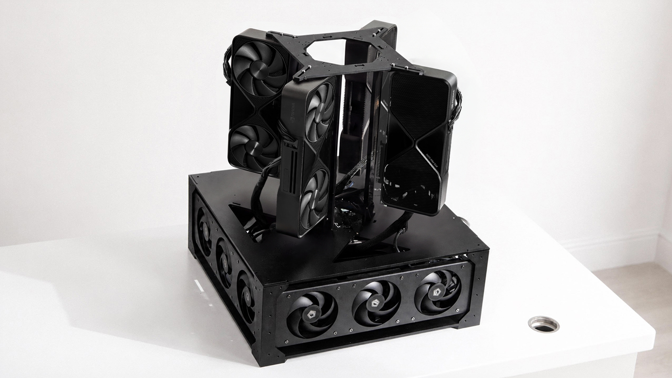 The 4× 6000 build — four RTX PRO 6000s stacked in the open cube frame over the fan base