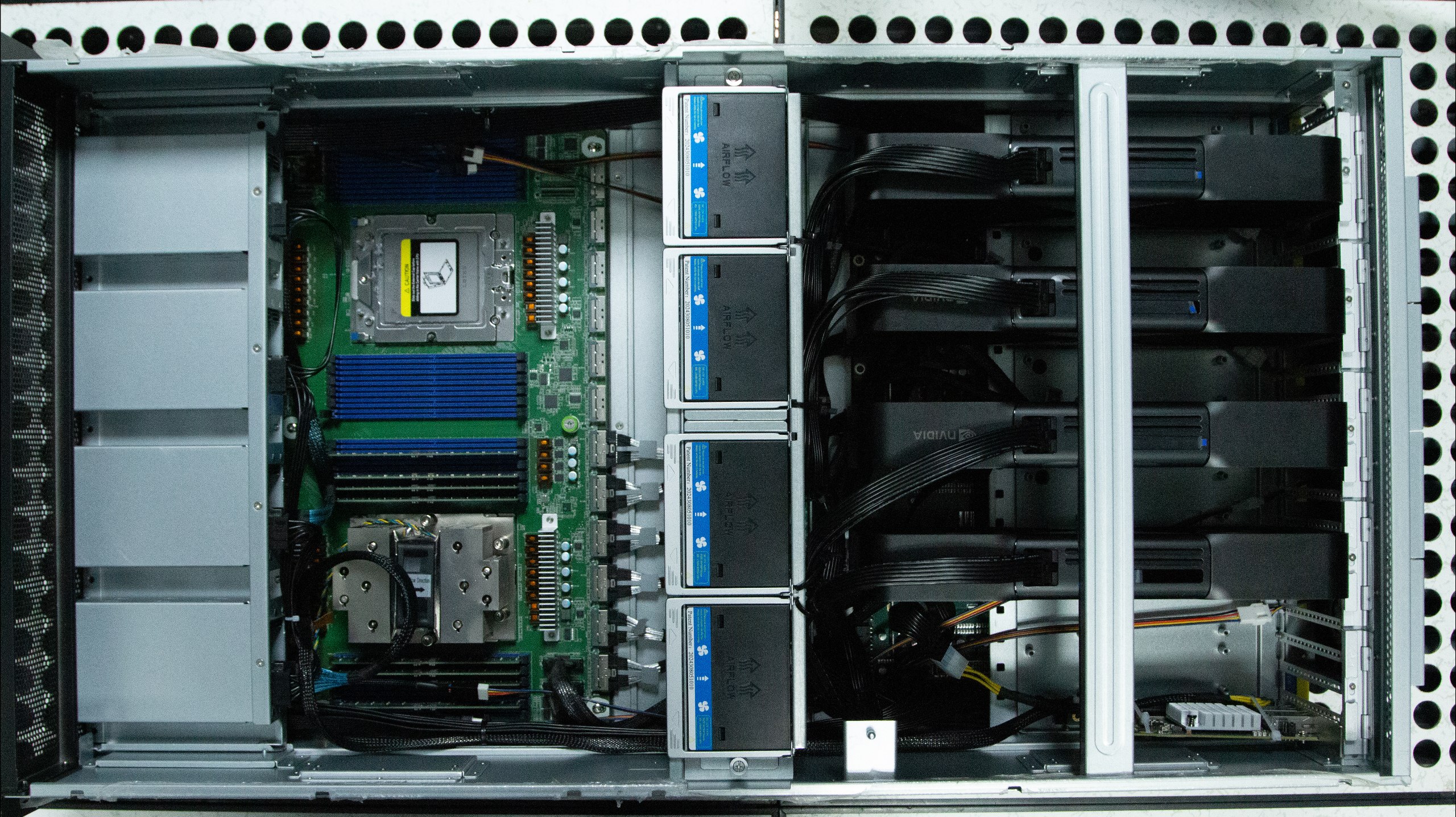 Top-down — the dual-SP5 board, populated socket, RAM, the AIRFLOW fan wall, and the four GPUs