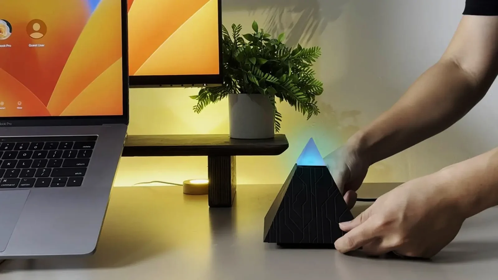 Autonomous Intern on a desk beside a laptop, tip glowing blue