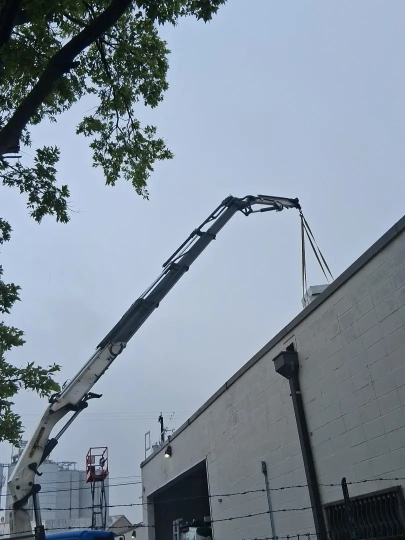 Crane lifting roofing materials onto a Houston commercial roof