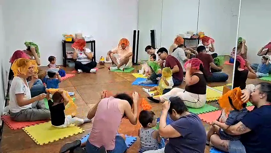 Familias sentadas en círculo cantando