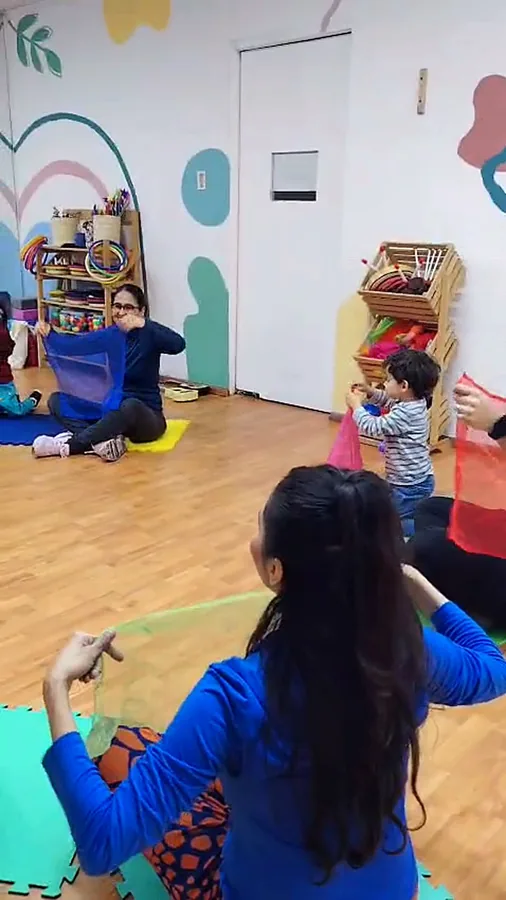 Mamá jugando con su peque bajo una tela
