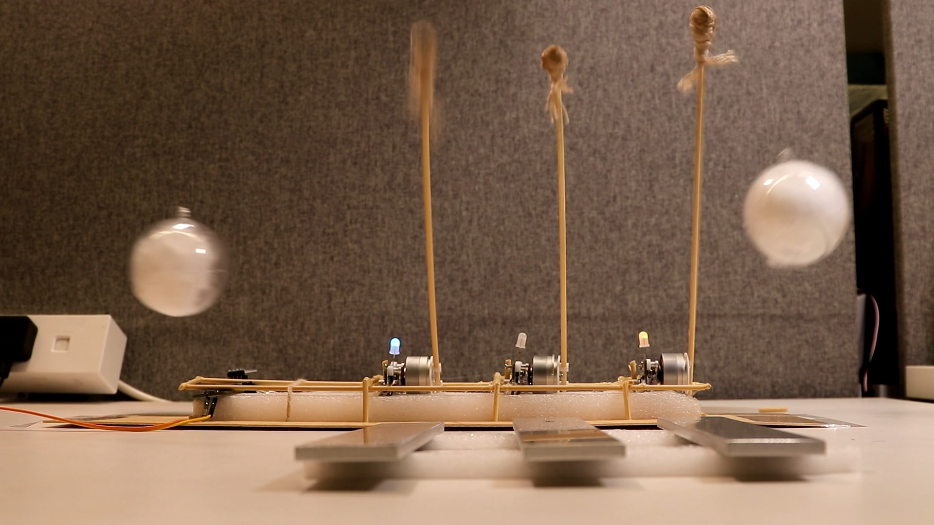 Banner image: the white balls of the controllers swinging in the air, in front of a prototype self-playing glockenspiel