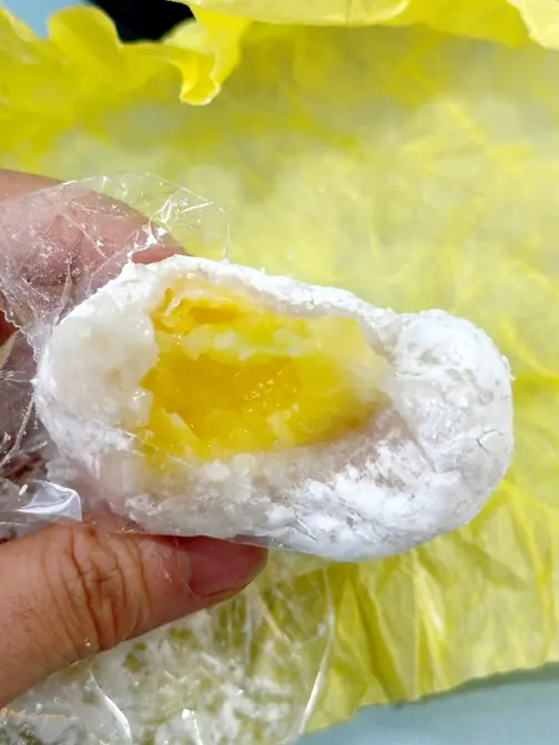Hand holding yellow fruit mochi
