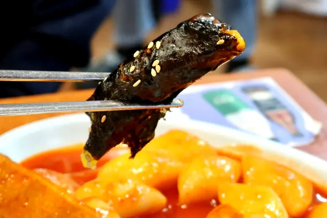 Chopsticks holding Korean mini gimbap roll