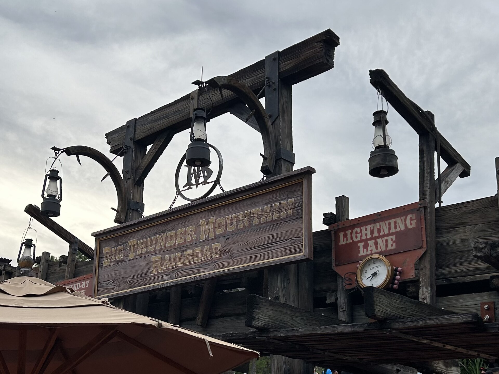 The entrance to Big Thunder Mountain Railroad at Magic Kingdom, Walt Disney World, showing the Lightning Lane entrance sign and return-time clock.