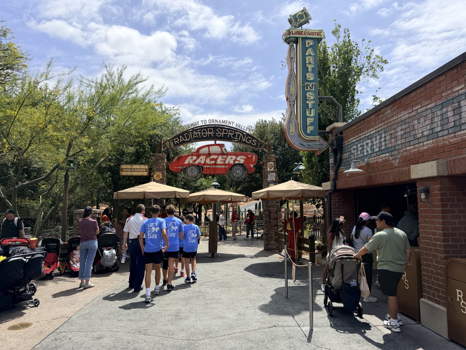 The Radiator Springs Racers entrance arch in Cars Land at Disney California Adventure — the Gateway to Ornament Valley arch with the red Racers car sign and the Luigi's Parts 'N' Stuff tower.