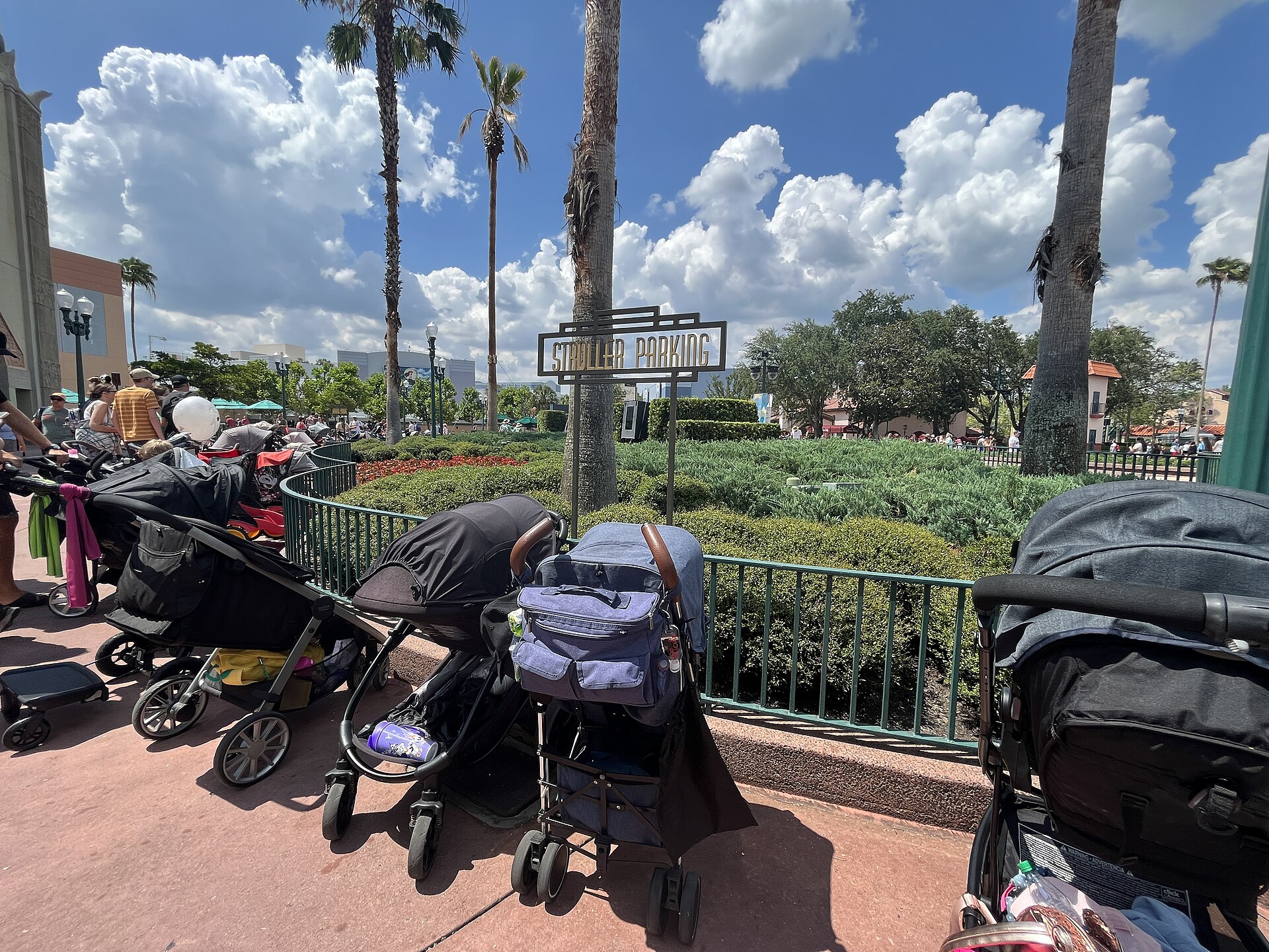 A STROLLER PARKING sign at Disney's Hollywood Studios, Walt Disney World, with parked strollers in the foreground under palm trees.