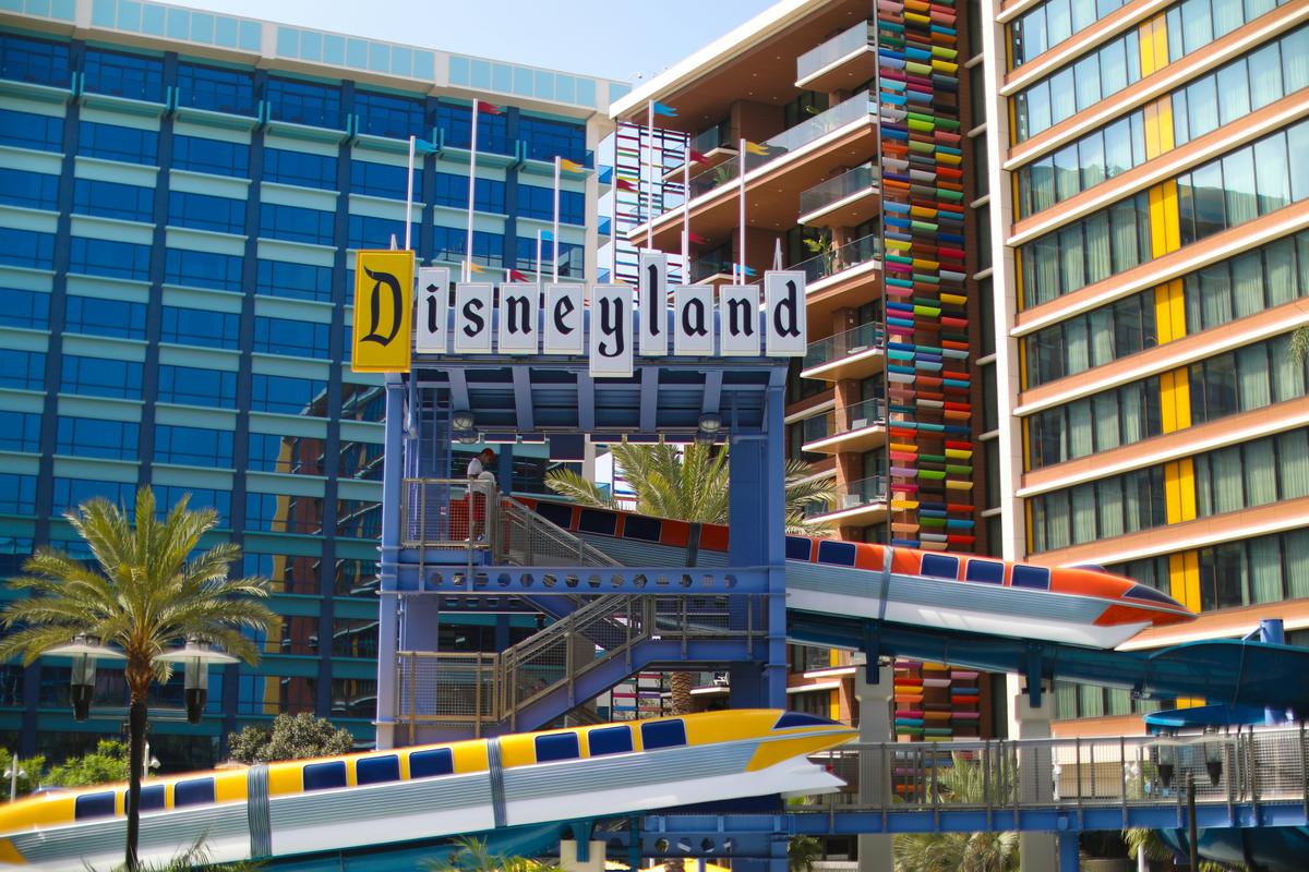 The Disneyland Hotel with the monorail running through the colorful resort complex on a sunny day