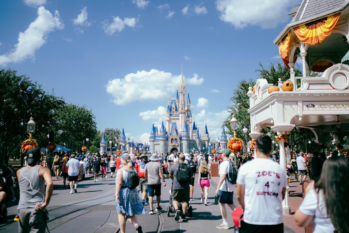 Families watching Happily Ever After fireworks on Main Street USA at Magic Kingdom with Cinderella Castle lit up blue