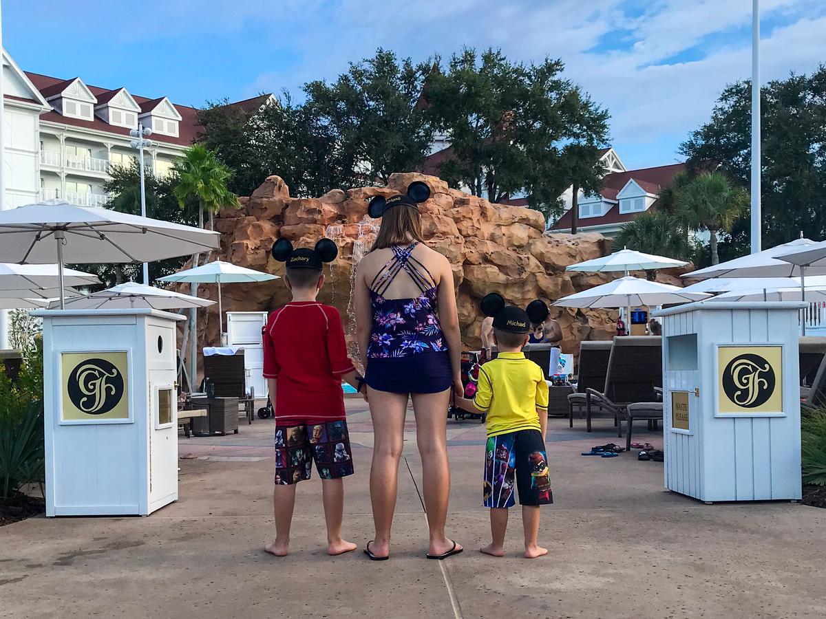 Three children wearing personalized Mickey Mouse ears at the Grand Floridian Resort pool at Walt Disney World