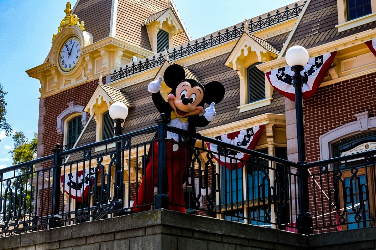 Mickey Mouse waving from the Main Street train station balcony at Disneyland