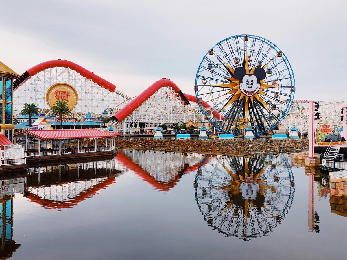 Pixar Pier at Disney California Adventure with the Incredicoaster and Mickey ferris wheel reflected in the water