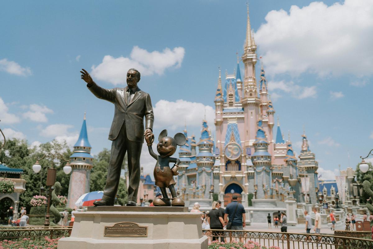 Guest wearing Minnie Mouse ears looking toward Cinderella Castle at Magic Kingdom
