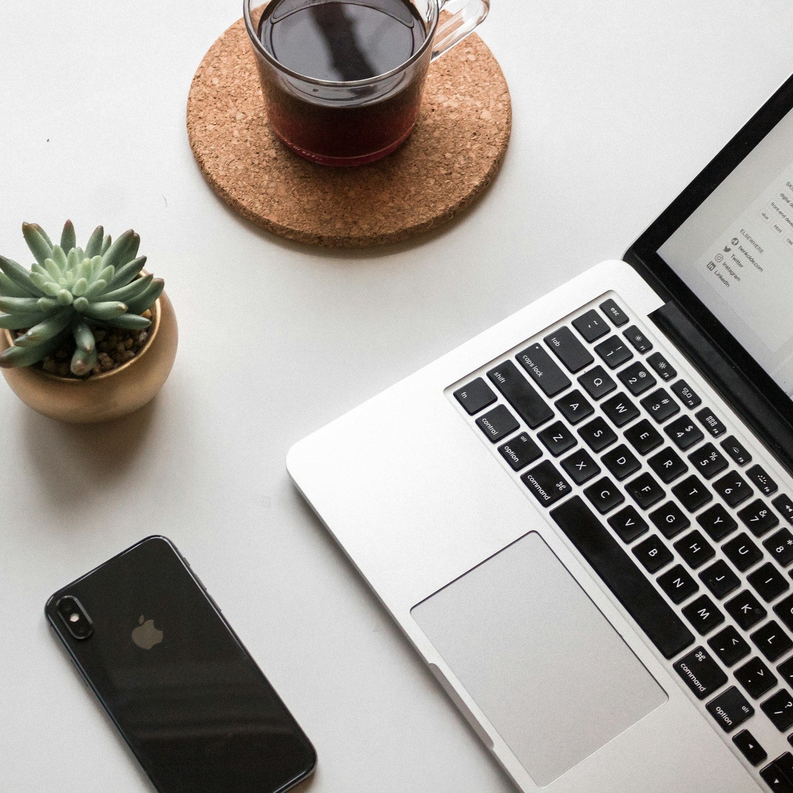 A smartphone beside a laptop on a desk, the synced workflow