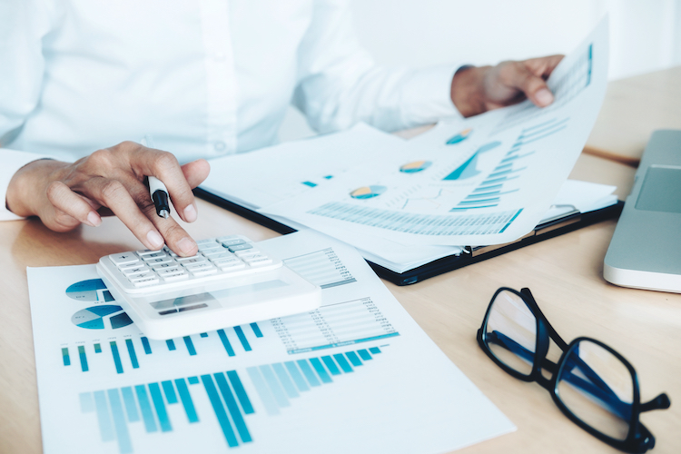 Calculator over financial charts. The surviving skill is checking the machine's work, not doing it.